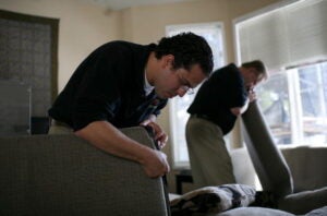 men looking through couch cushions