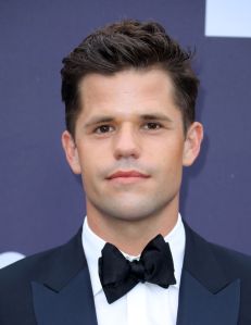 Charlie Carver wearing a suit and bowtie in this close-up shot.