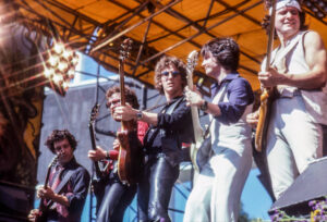 Blue Oyster Cult performing on stage in the 1970s 3 of the band memebers pictured or standing side by side playing guitars