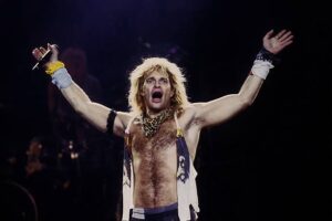David Lee roth on stage with his arms in the air and his mouth wide open