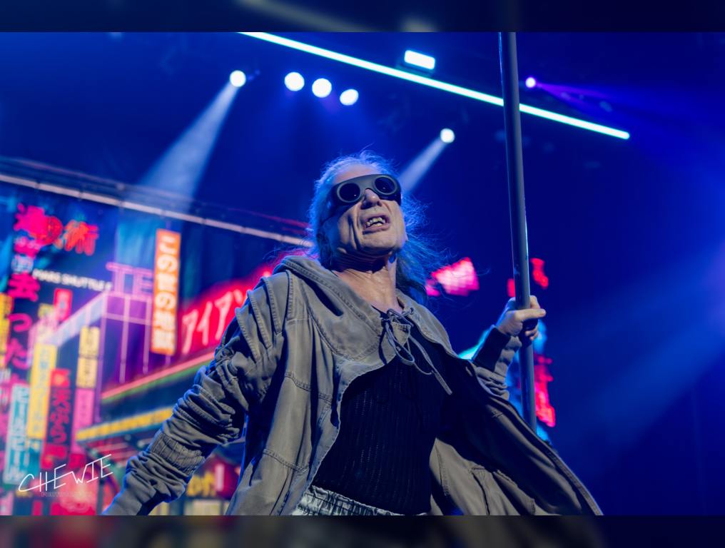 Iron Maiden's vocalist Bruce Dickinson holds his mic stand in the air