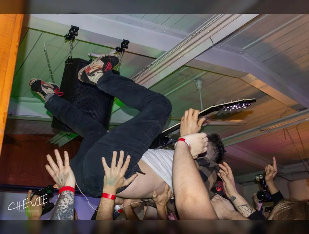 The Dillinger Escape Plan's guitarist Ben Weinman plays while crowdsurfing.